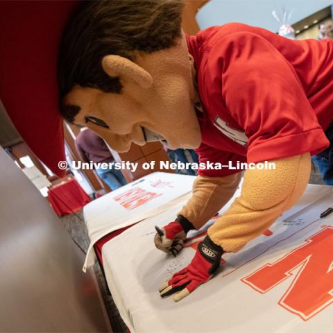 Herbie signs one of the four Alumni N150 flags. The flags will travel around the world to various alumni chapters and be signed. They will return in the fall and be hung for homecoming weekend for all to see. Everyone was invited to enjoy a cupcake and join in the festivities with their Husker friends at the Wick Alumni Center, Friday February 15th. The Nebraska Charter was available to view, along with other historical items. Copies of Dear Old Nebraska U could be purchased and signed. Charter Day at the Wick Alumni. February 15th, 2019. Photo by Gregory Nathan / University Communication.